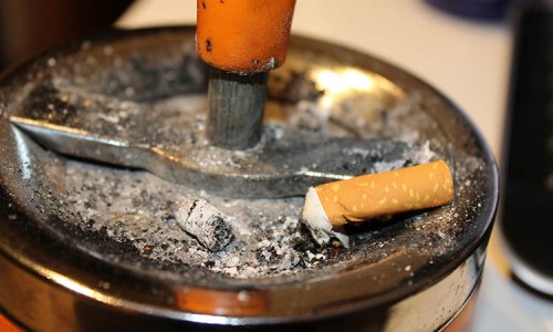 Bild på cigarett som fimpats i askkopp
