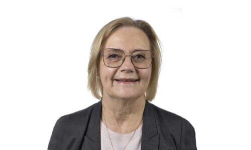 Porträttfoto på kvinna med svart kostym och vit tröja.