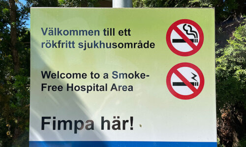 Bild på skylt där det står välkommen till rökfritt sjukhusområde och fimpa här. Bilden syftar till att visa rökfria vårdmiljöer.