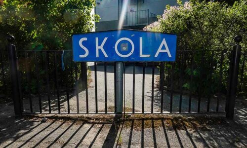 bild på grind med skylt där det står skola, som gestaltar Nikotinfri skoltid